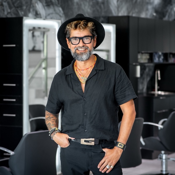 Carlos wearing a hat and ayeglasses possing for the camera he looks happy