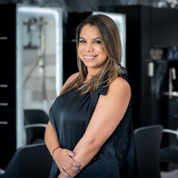 Dina our salon cordinator possing to the camera smiling showing off her beautiful hair style