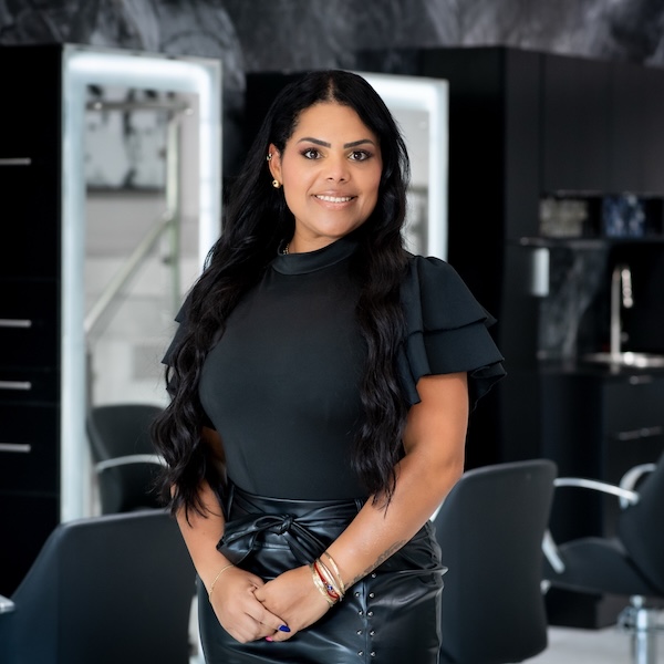 Yuliet our hair stylist has her hair long wearing a short shirt and pants