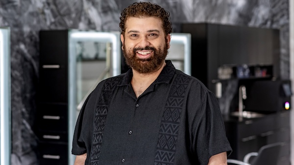 Bruce our hjairstylist smiling and wearing his beautiful curly hair